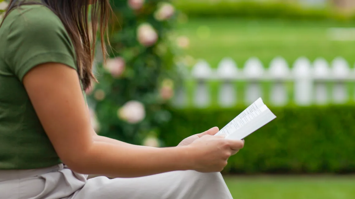 mujer sentada afuera leyendo la Biblia